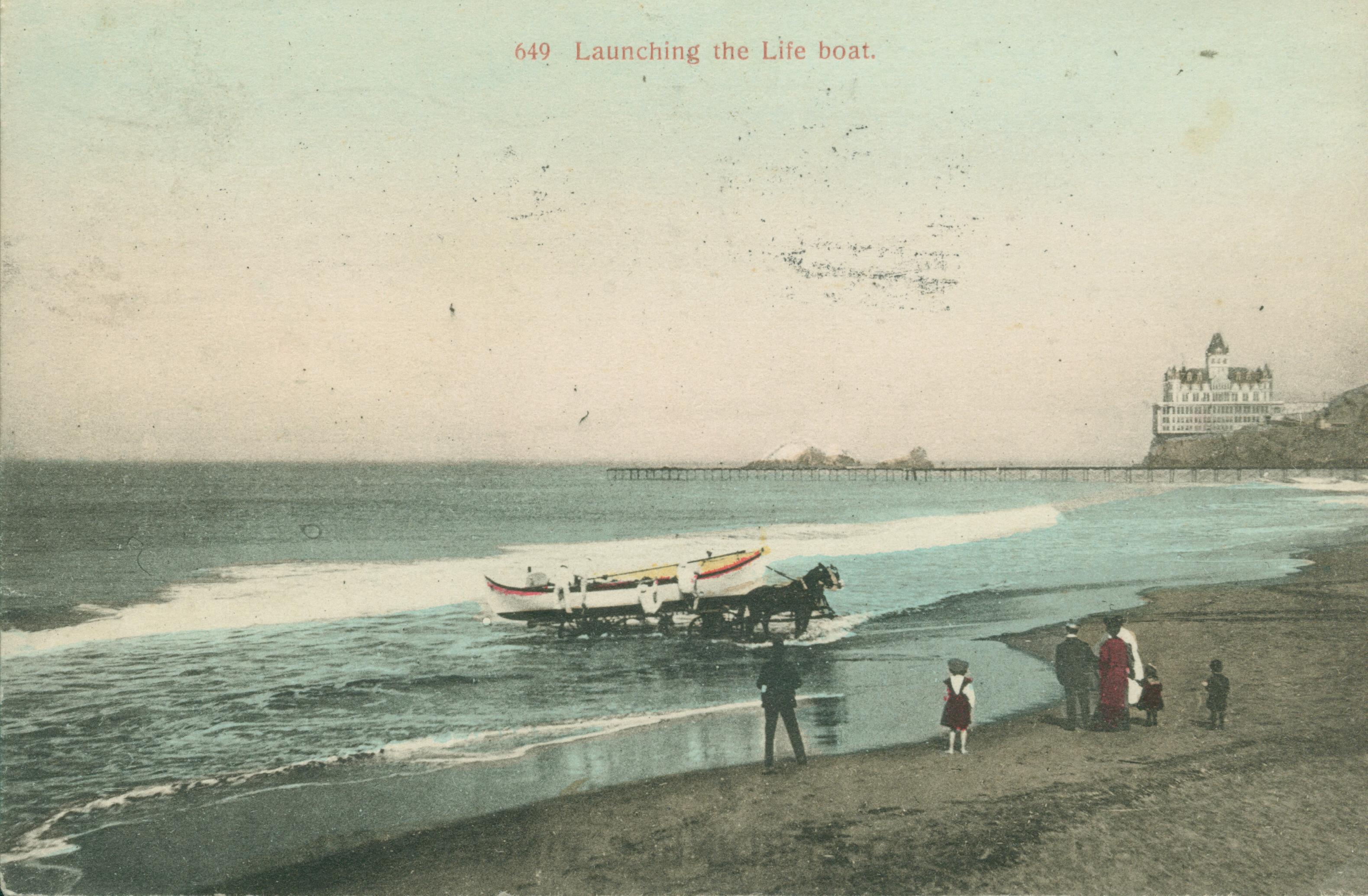 Shows a lifeboat being launched with the old Cliff House in the background.